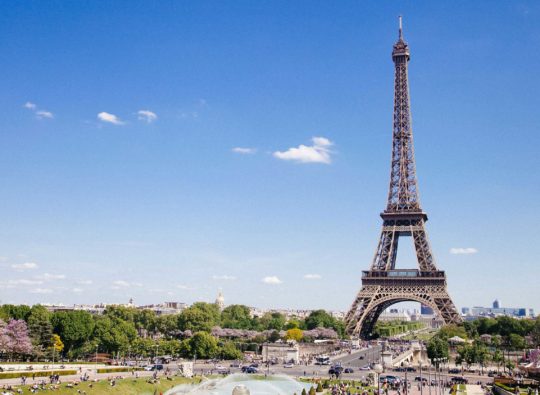 Iconic Eiffel Tower standing tall against a clear blue sky, epitomising the thrill of driving in France for Channel Island residents.