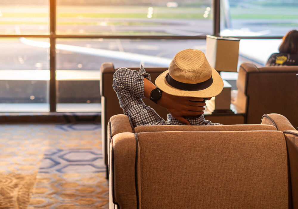 Traveller at airport lounge using SmartDelay Plus service from Islands Insurance for a comfortable wait during travel delay.